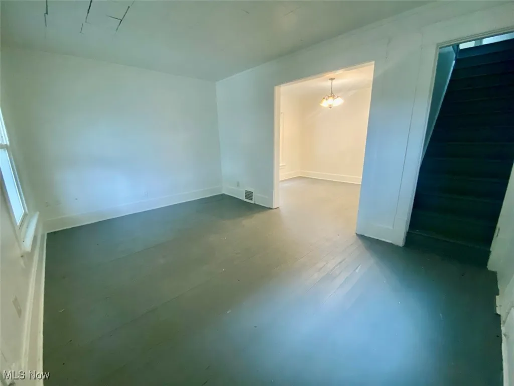 Spare room with stairway and a chandelier