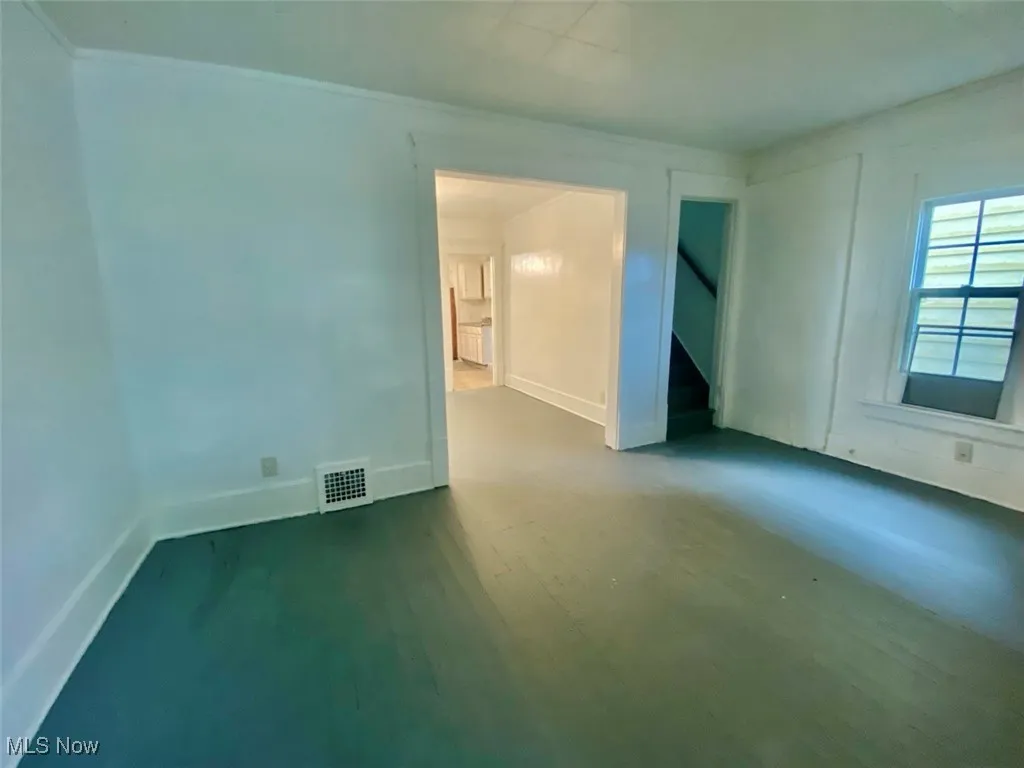 Unfurnished room featuring a decorative wall