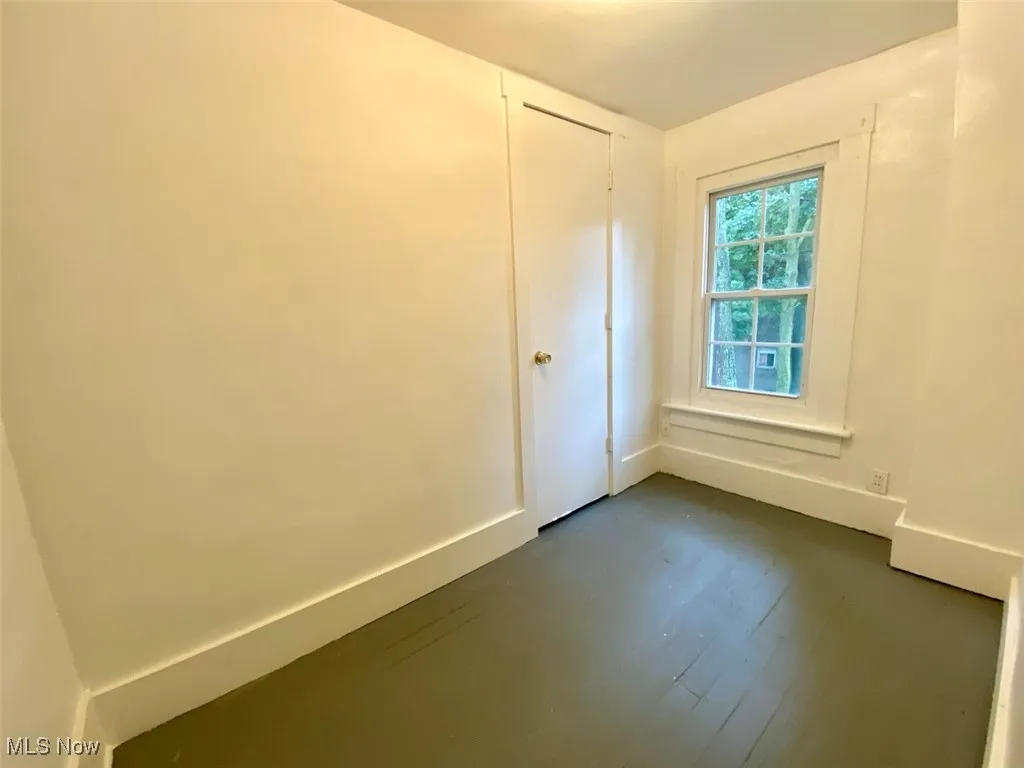 Unfurnished room with baseboards and dark wood finished floors
