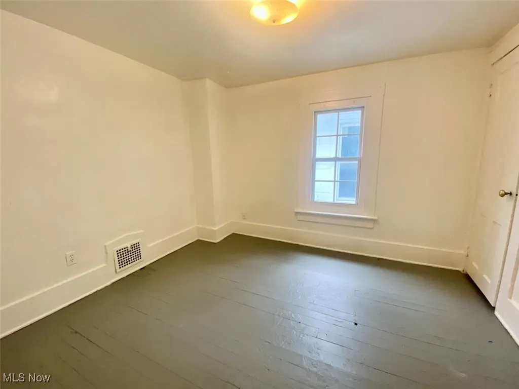 Spare room with dark wood-style flooring