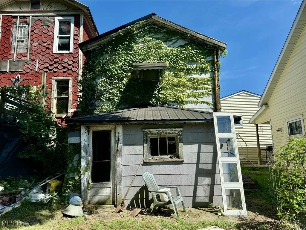 Back of property with a metal roof and an outbuilding