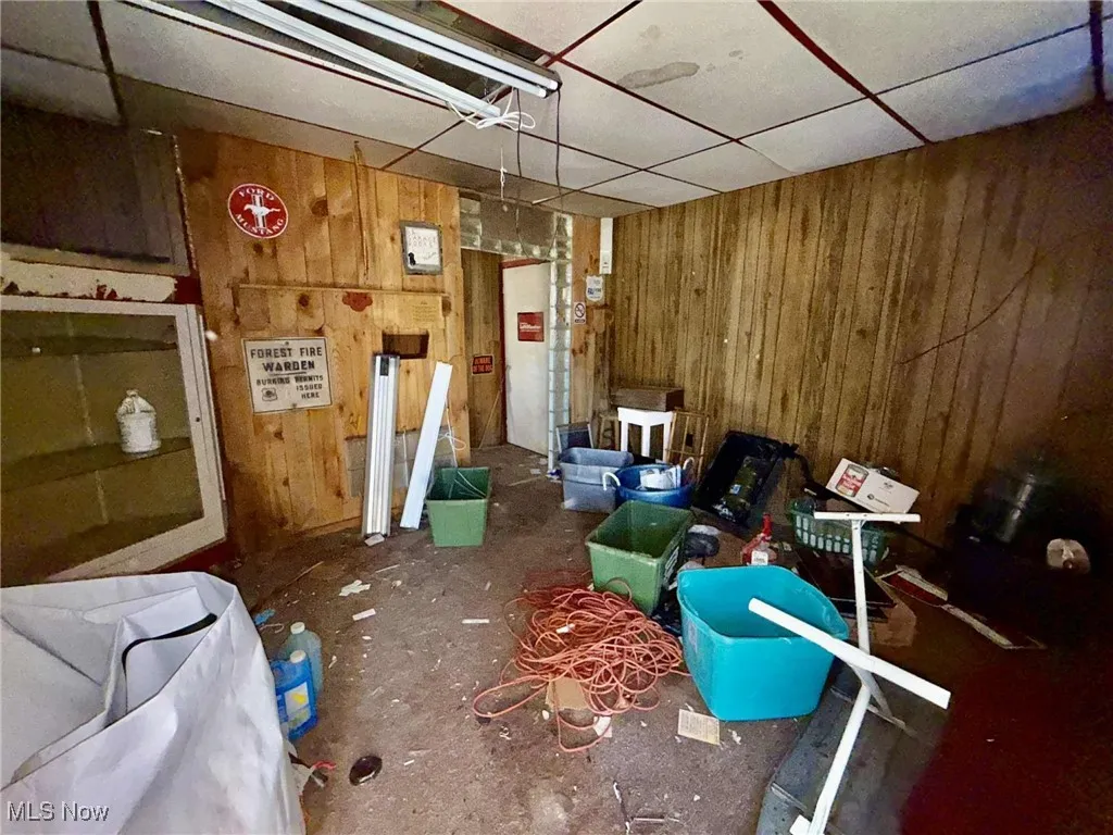 Miscellaneous room with wooden walls and a drop ceiling