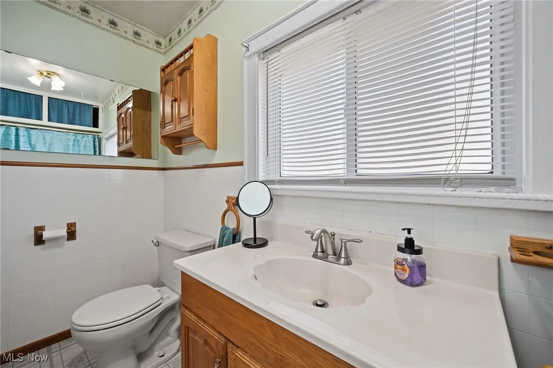 Bathroom with vanity and tile walls