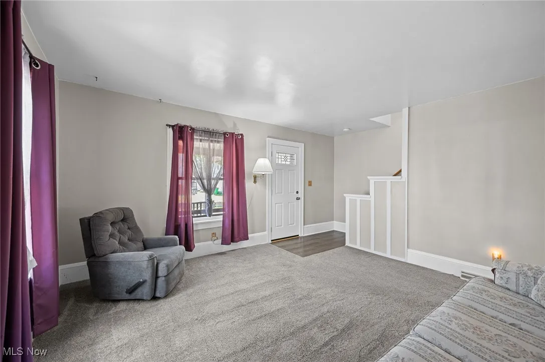 Living area featuring carpet flooring and stairs