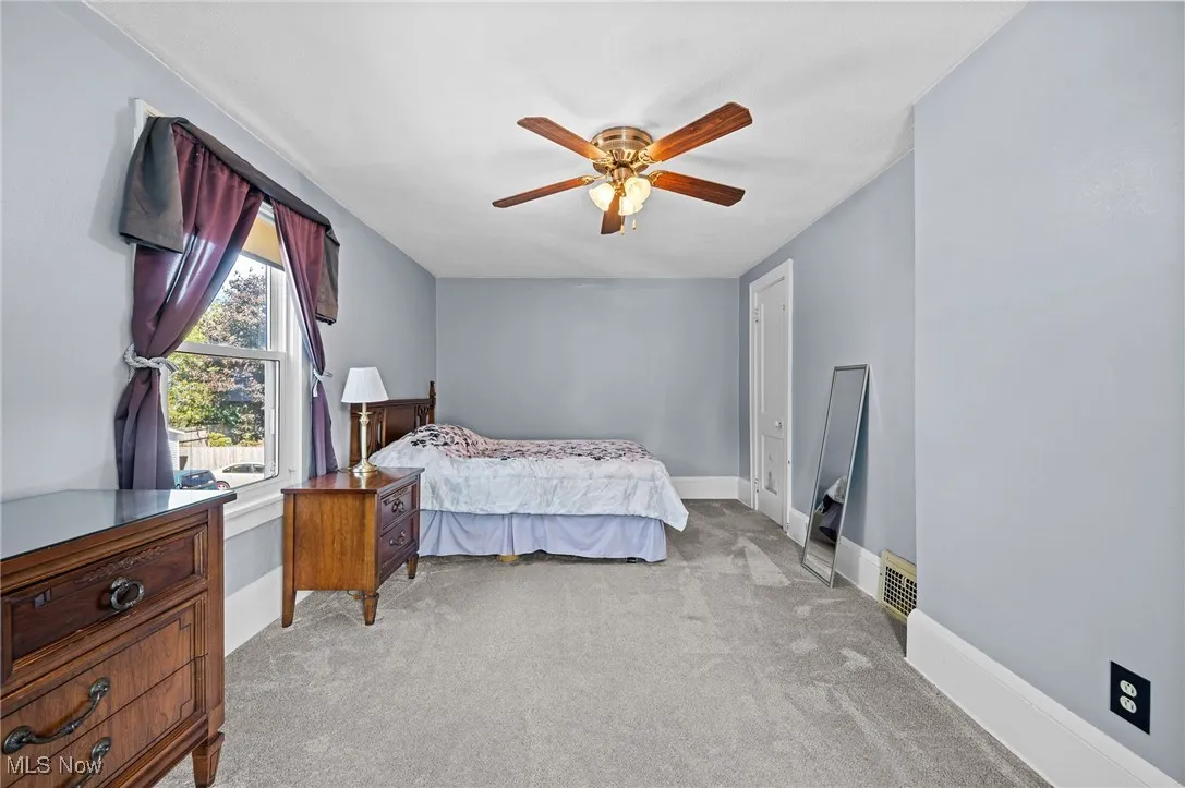 Bedroom featuring light colored carpet and a ceiling fan