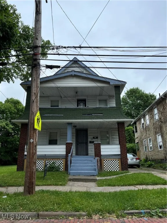 View of front of house with covered porch and a front yard