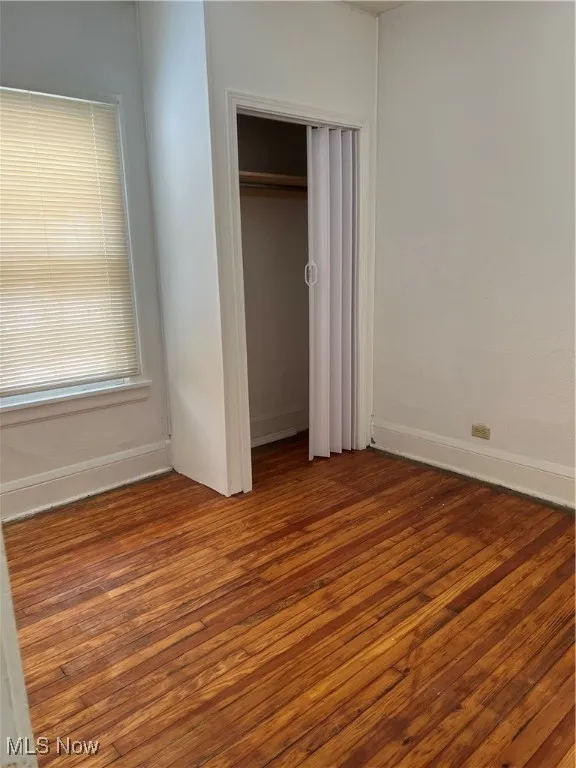 Unfurnished bedroom featuring hardwood / wood-style floors and a closet