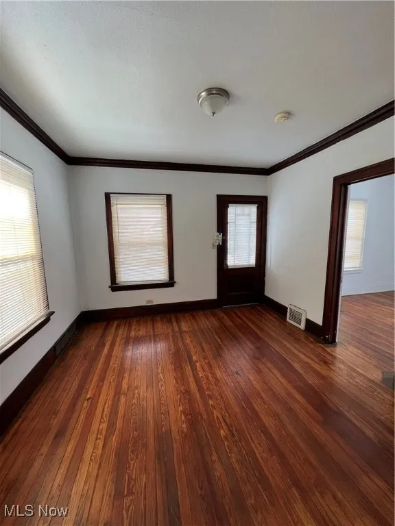 Entrance foyer with dark wood finished floors and crown molding