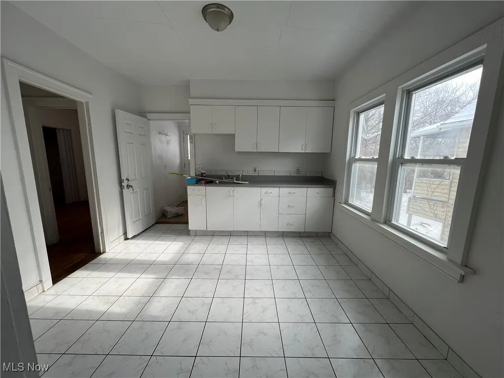 Kitchen with dark countertops and white cabinets
