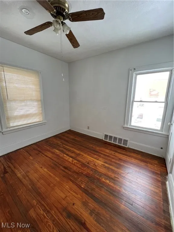 Empty room featuring dark wood finished floors and a textured ceiling