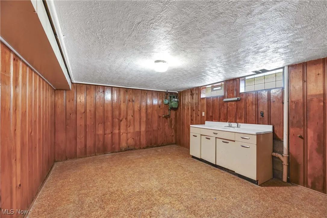  Wooden walls, light countertops, and a textured ceiling