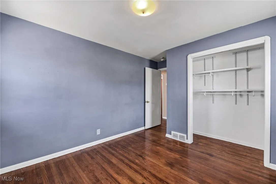 Unfurnished bedroom with dark wood-type flooring and a closet