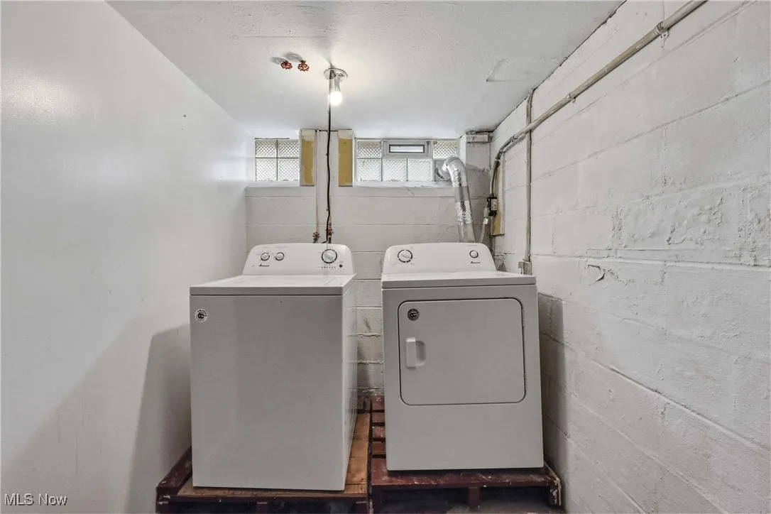 Laundry room featuring washer and clothes dryer and a textured ceiling