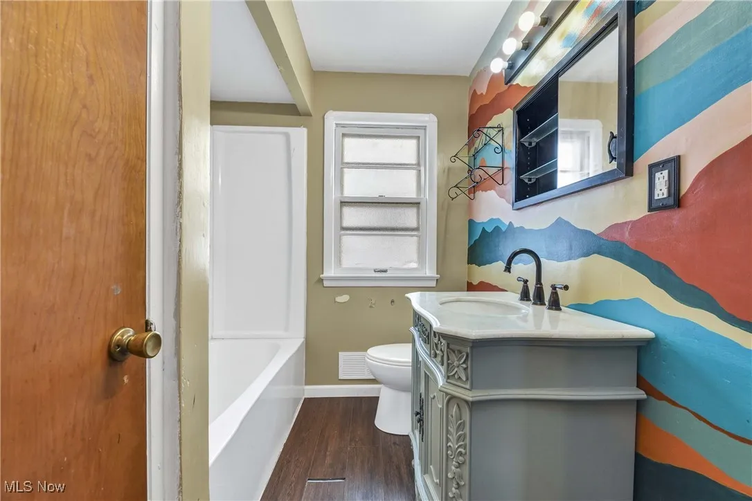 Full bathroom with vanity and dark wood-type flooring