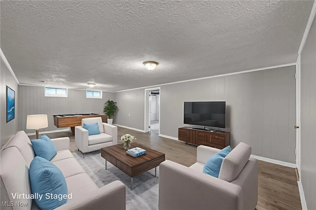Living area featuring billiards, wood finished floors, wooden walls, and ornamental molding