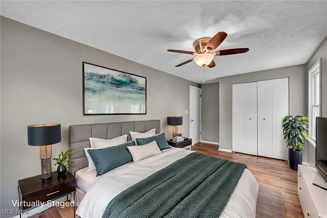Bedroom with light wood-type flooring, a closet, ceiling fan, and a textured ceiling