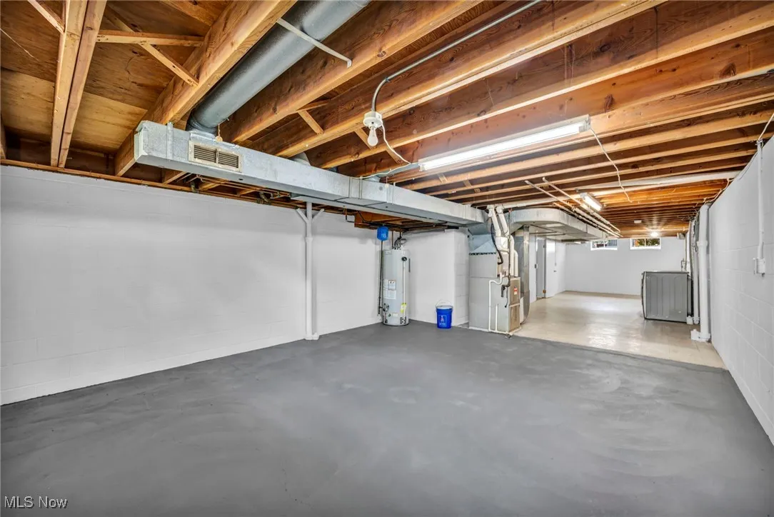 Below grade area featuring heating unit and water heater