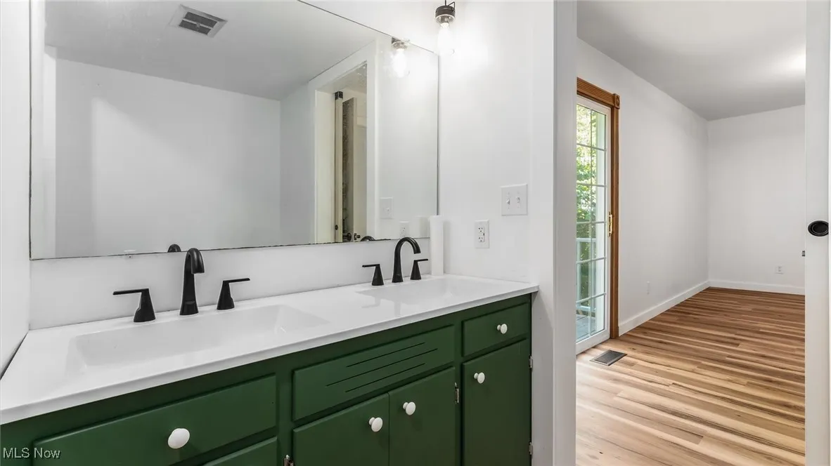 Bathroom with double vanity and light wood-style floors