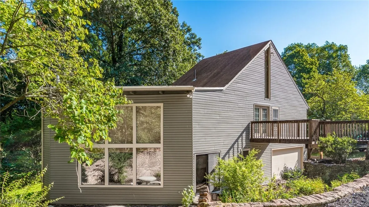 View of home's exterior with a garage and a deck