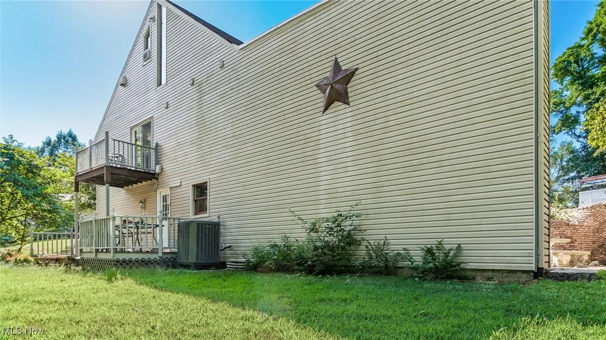 View of side of home featuring a yard
