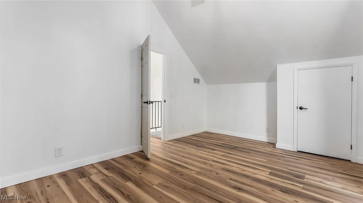 Bonus room with lofted ceiling and wood finished floors