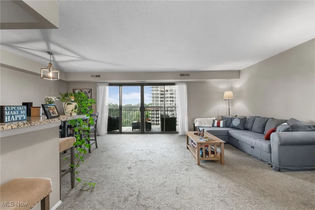 Living area featuring carpet and a textured ceiling