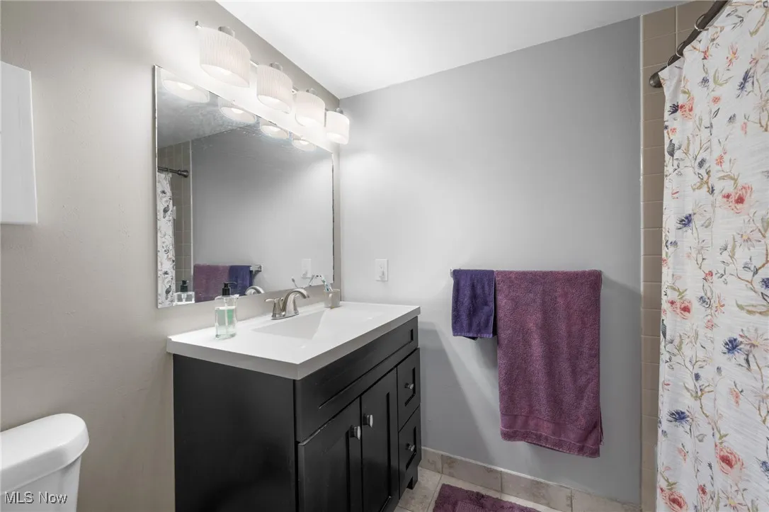 Full bathroom featuring vanity, light tile patterned floors