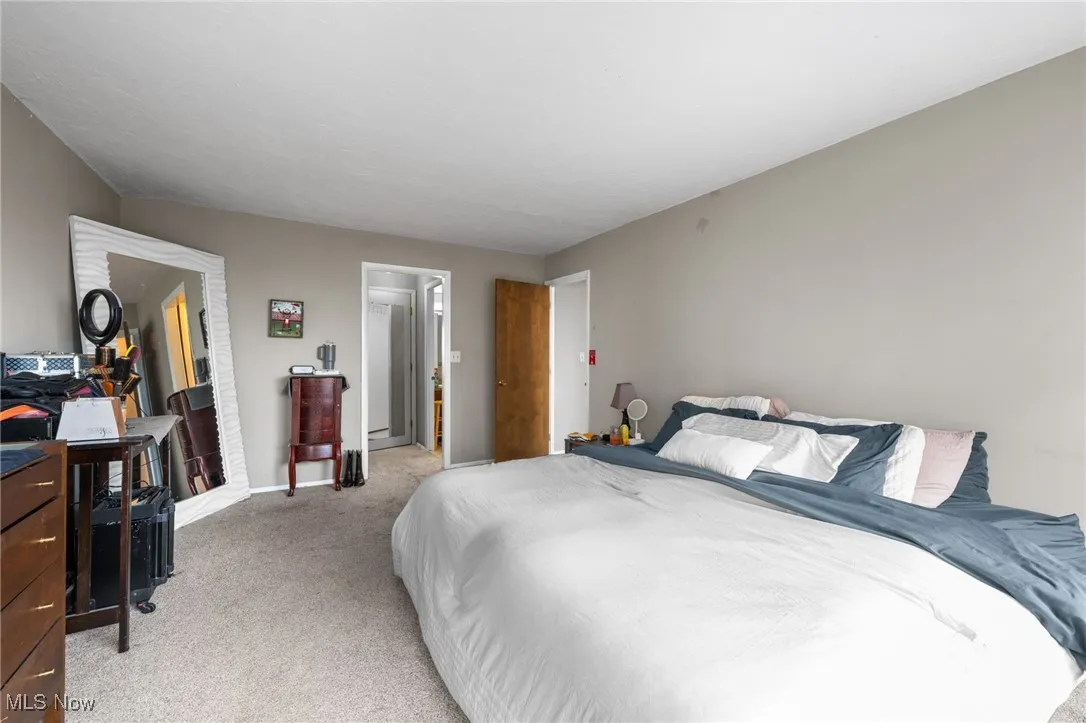 Primary bedroom with carpet and baseboards