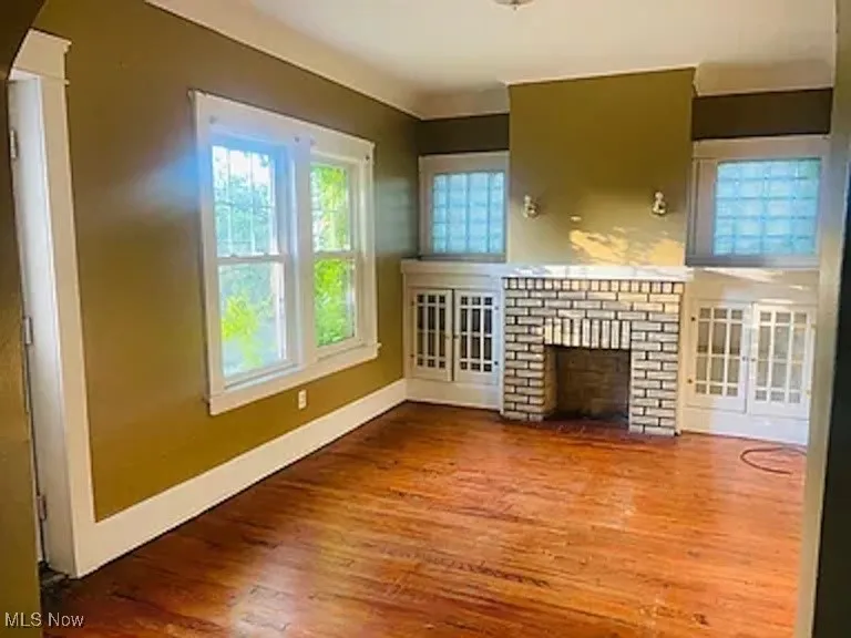 Unfurnished living room featuring a fireplace and wood finished floors