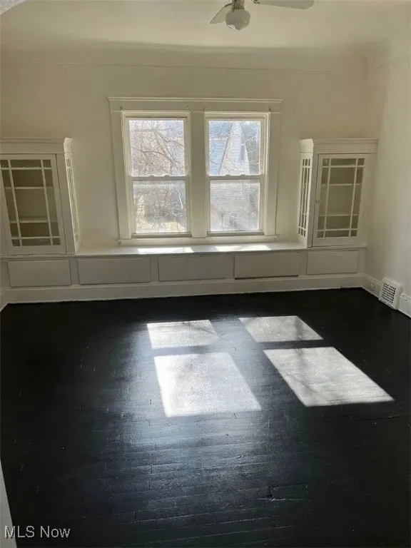 Spare room featuring dark wood finished floors and baseboards