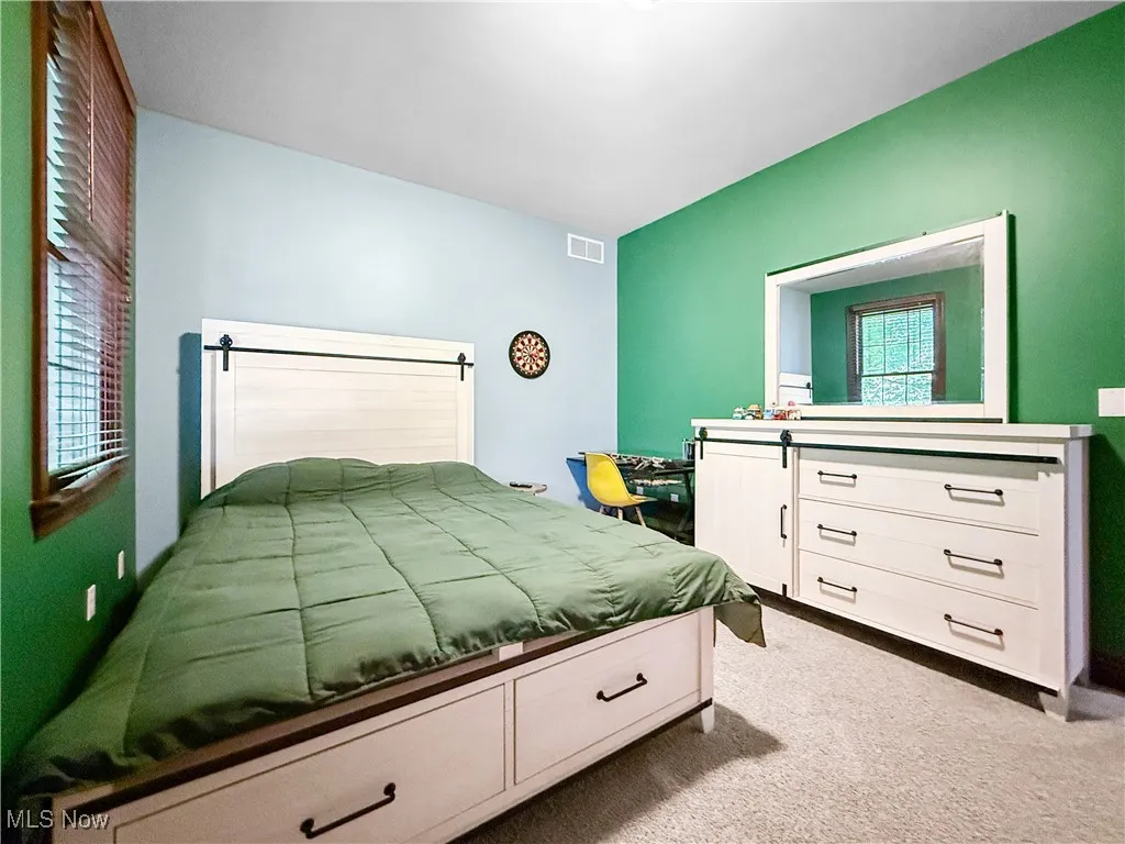 Bedroom featuring light carpet