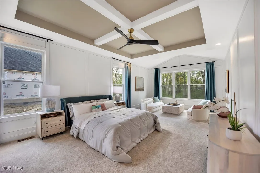 Primary Bedroom with multiple windows, floor to ceiling wainscotting, carpet flooring, ceiling fan, sitting room and coffered ceiling