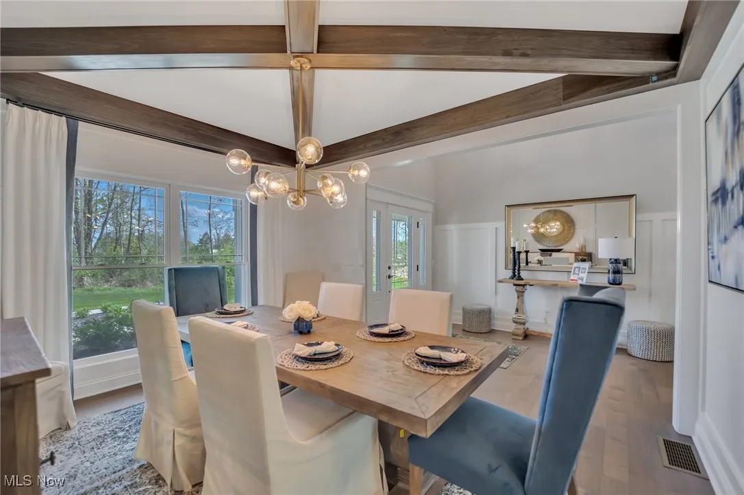 Dining Room with beamed ceiling, a chandelier, window treatments and hardwood flooring