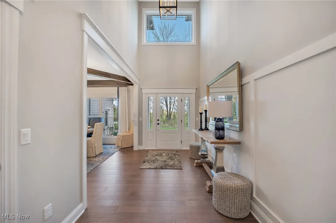 Entrance foyer featuring a high ceiling wainscotting & hardwood flooring