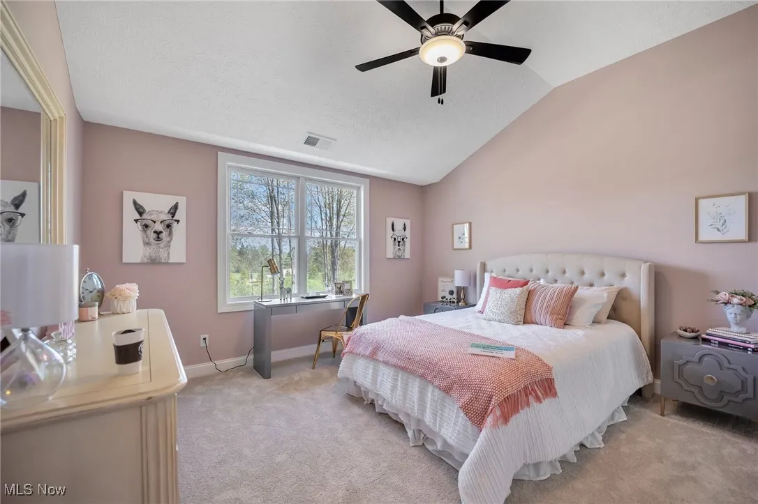 Bedroom featuring carpet floors, vaulted ceiling, ceiling fan and textured ceiling