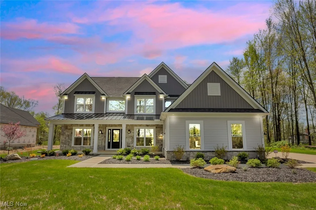 View of front of home featuring covered porch, a lawn, shake siding