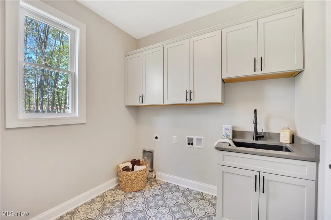 Laundry Room with tile flooring, cabinetry and laundry sink in cabinet with quartz countertops.