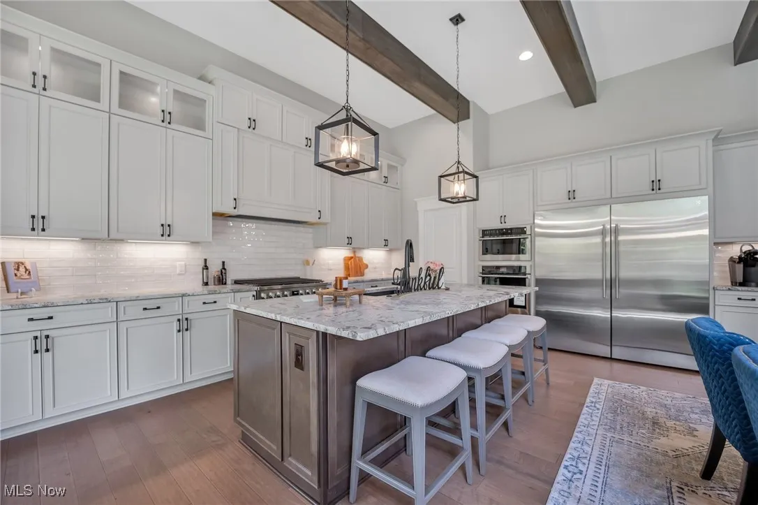 12' tall Kitchen featuring glass insert cabinets, large island, tile backsplash, hardwood flooring, stainless steel appliances and leather finished granite counters