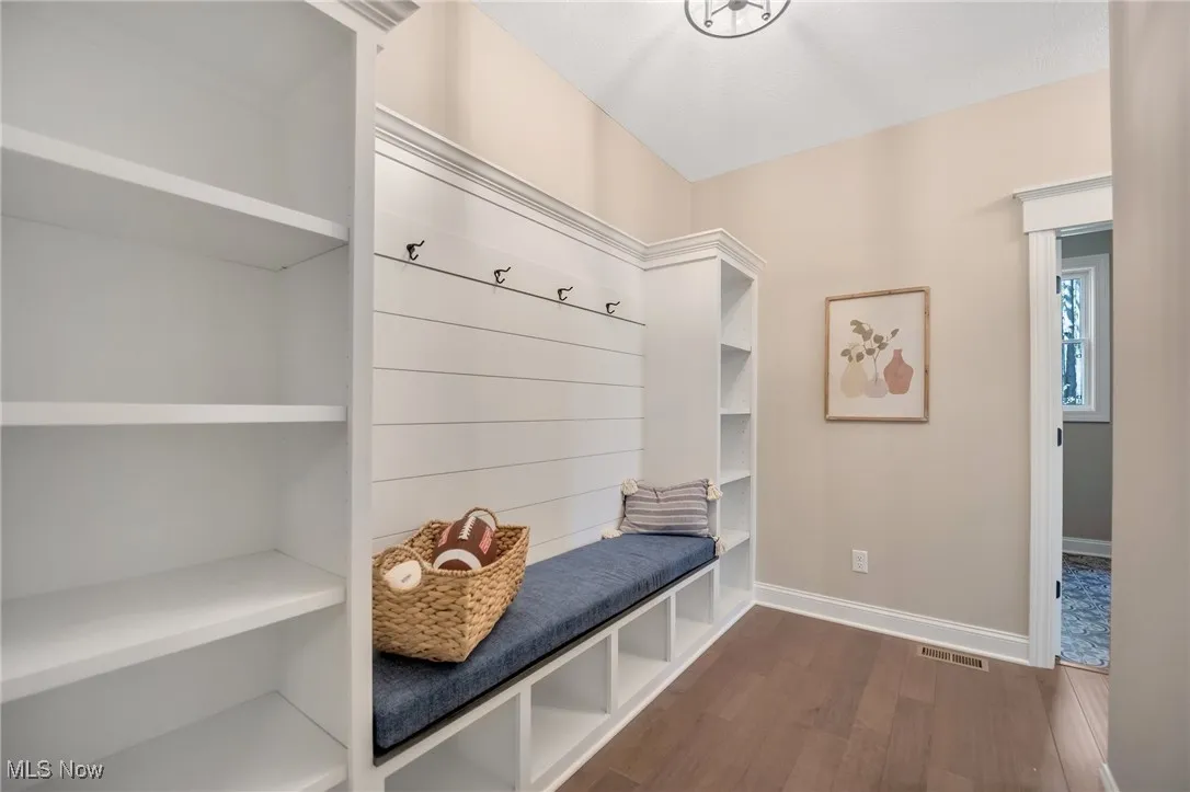 Mudroom featuring built in cubbies and hardwood flooring