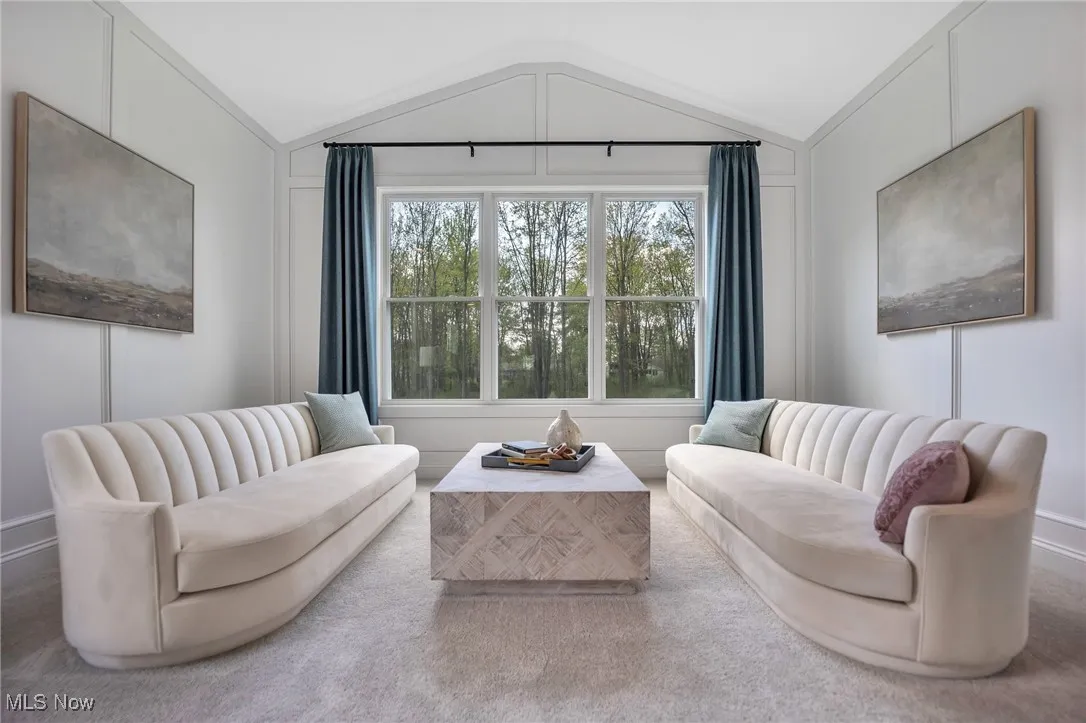 Sitting room with vaulted ceiling, floor to ceiling wainscotting and carpet floors