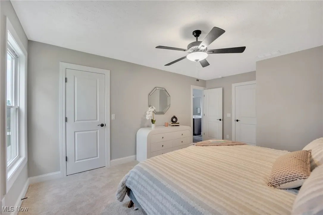 Bedroom featuring light carpet and a ceiling fan