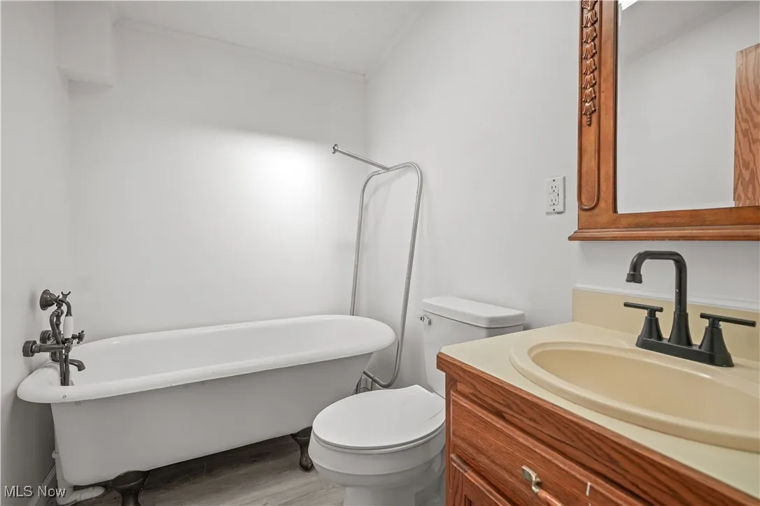 Bathroom with a freestanding tub, vanity, and light wood finished floors