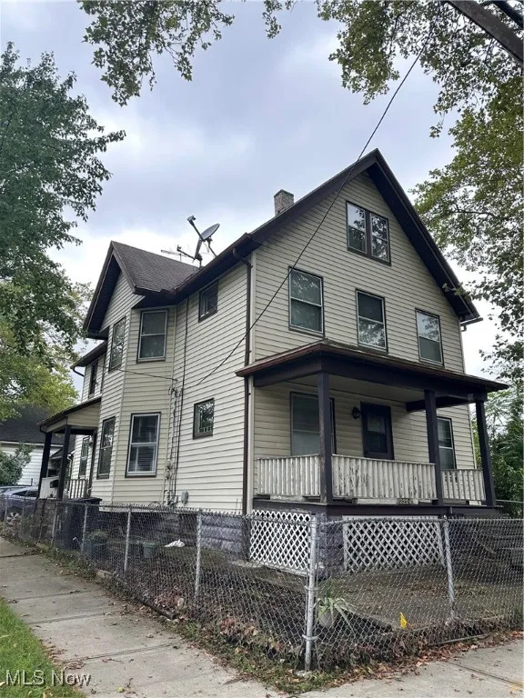 View of front of property featuring a porch, a fenced front yard, and a chimney
