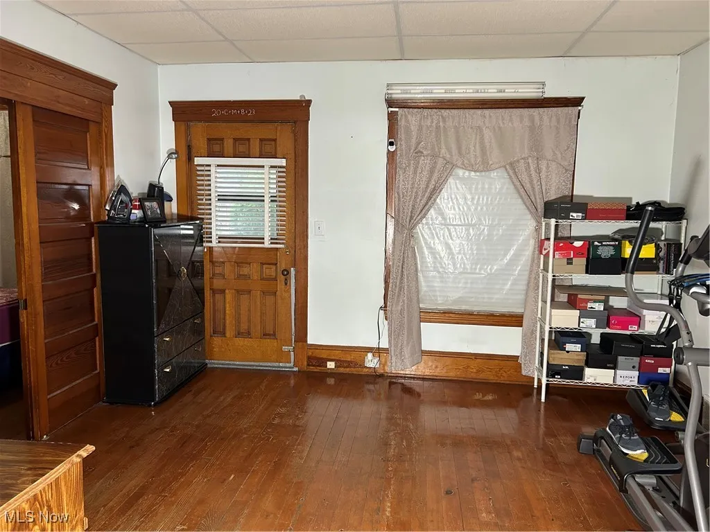 Entryway featuring dark wood-type flooring and a drop ceiling