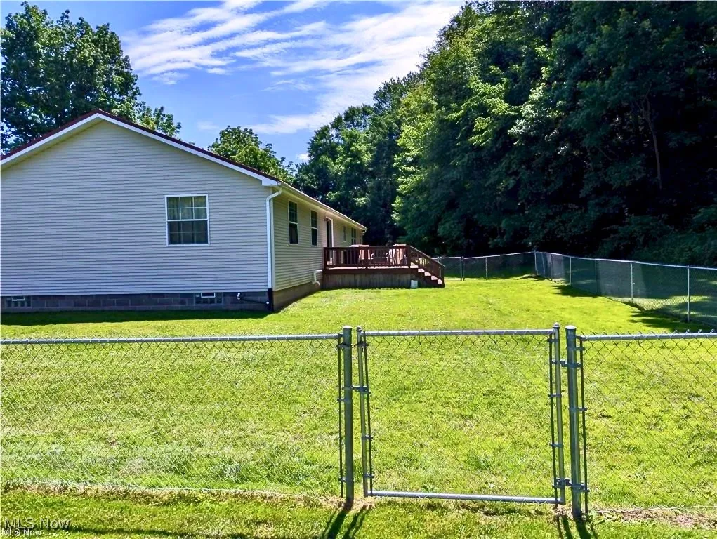 Fenced backyard with a gate and a wooden deck