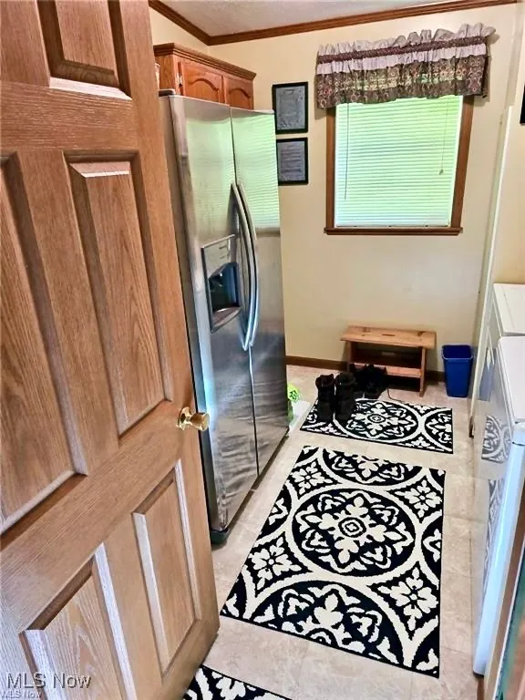 Bathroom featuring crown molding and light tile patterned floors