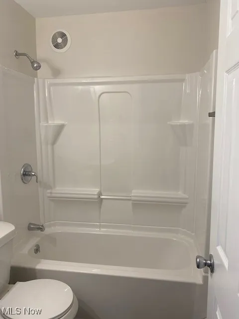 Bathroom featuring washtub / shower combination and toilet