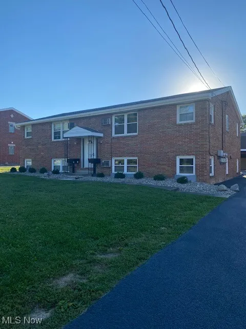 View of front of house featuring brick siding and a front yard
