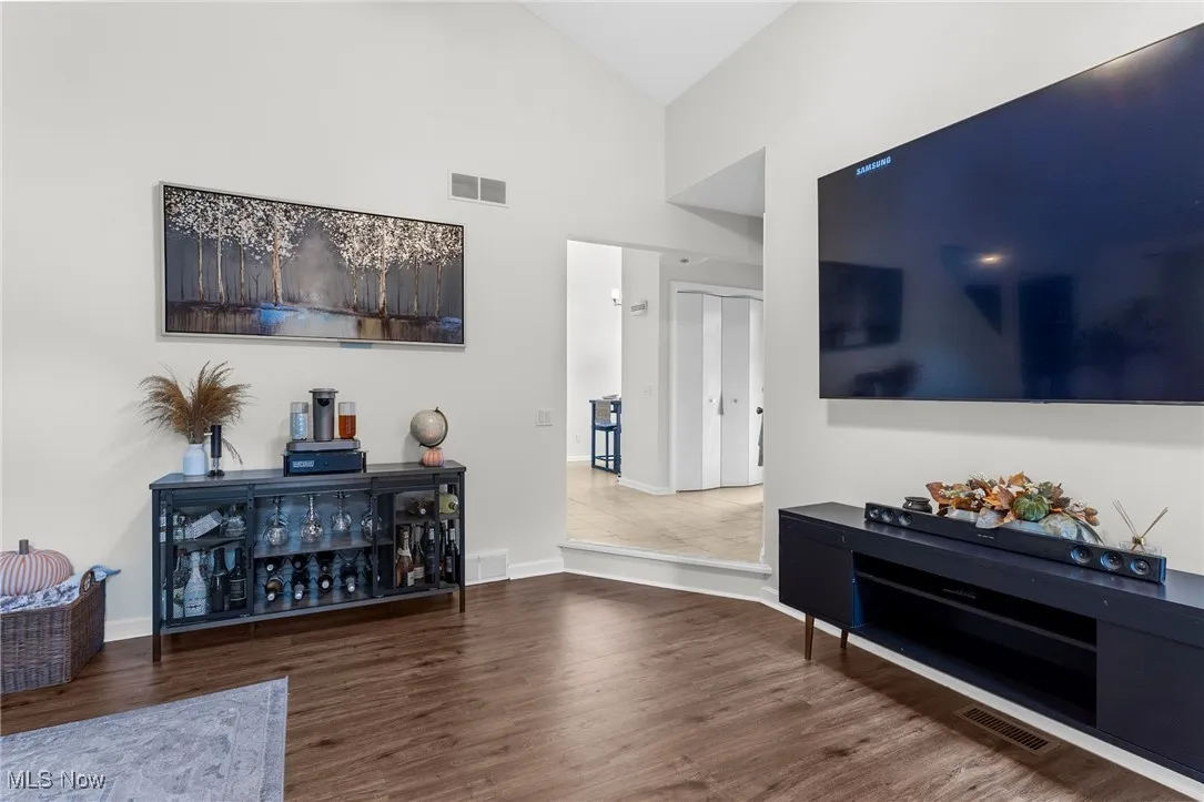 Living room with high vaulted ceiling and wood finished floors