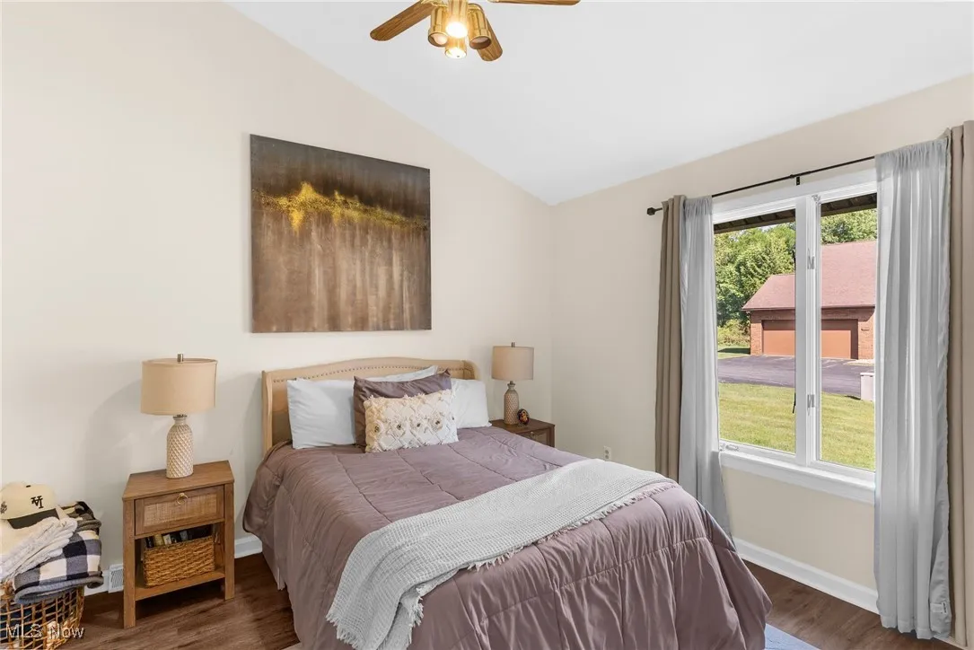 Bedroom featuring wood finished floors, vaulted ceiling, and ceiling fan